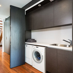 Modern Laundry Room Wales Modern Laundry Room · European Laundry Design with concealed cabinetry behind large bi-fold doors in hallway Entry.