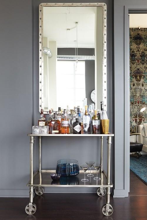 Hang an oversized mirror above a bar cart to create a focal point in a room. See all 15 CREATIVE ways to use and style a bar cart in your home.