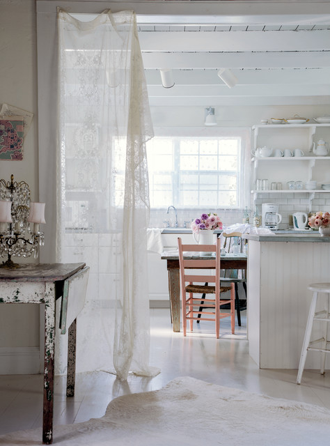A white Shabby Chic kitchen with vintage furniture, beadboard, and open shelves