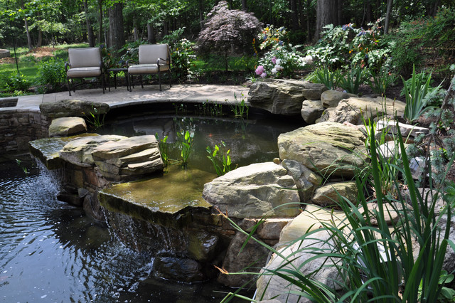 Two-tiered koi pond with plantings and natural stone ...