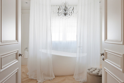Saratoga Springs-based Teakwood Builders bathroom lighting design idea book: Gauzy curtains gracefully diffuse natural light while a chandelier adds sparkle and elegance. Teakwood Builders, kitchen and bath remodeler, custom home builder and general contractor Saratoga Springs and Capital Region.