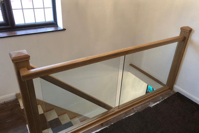 Small contemporary wood straight glass railing staircase in Other with wood risers.