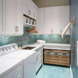 Inspiration for a small nautical l-shaped separated utility room in Jacksonville with a submerged sink, shaker cabinets, white cabinets, engineered stone countertops, concrete flooring, a side by side washer and dryer, turquoise floors and blue walls.