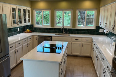 Example of a mid-sized minimalist u-shaped enclosed kitchen design in Austin with quartz countertops, green backsplash, ceramic backsplash and an island