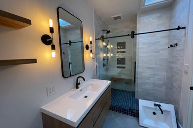 Inspiration for a mid-sized scandinavian 3/4 white tile and porcelain tile porcelain tile, gray floor and single-sink sliding shower door remodel in Seattle with flat-panel cabinets, brown cabinets, a one-piece toilet, gray walls, an integrated sink, solid surface countertops, white countertops, a niche and a floating vanity