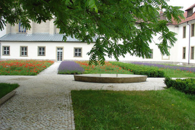 Großer Patio im Innenhof mit Wasserspiel und Natursteinplatten in Berlin