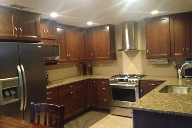 Inspiration for a mid-sized transitional u-shaped porcelain tile open concept kitchen remodel in Sacramento with a single-bowl sink, recessed-panel cabinets, dark wood cabinets, granite countertops, beige backsplash, stainless steel appliances and a peninsula