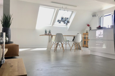 Mittelgroße Nordische Wohnküche ohne Kamin mit weißer Wandfarbe, Betonboden und grauem Boden in Stuttgart