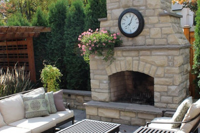 Patio - large traditional backyard stone patio idea in Toronto with a fire pit and no cover