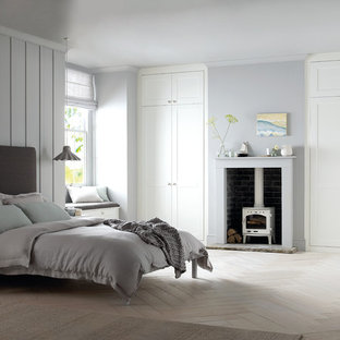 Mittelgroßes Klassisches Gästezimmer mit blauer Wandfarbe, hellem Holzboden und Kaminofen in West Midlands