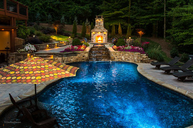 Inspiration for a large modern backyard custom-shaped pool in Atlanta with a water feature and concrete pavers.