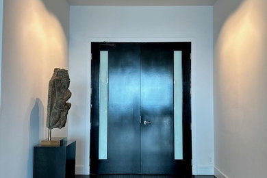 На фото: огромная входная дверь в восточном стиле с белыми стенами, полом из керамической плитки, черной входной дверью и черным полом с
