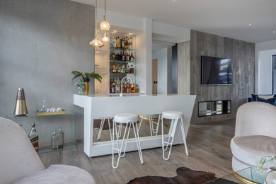 Large contemporary galley seated home bar in Auckland with an undermount sink, flat-panel cabinets, white cabinets, solid surface benchtops, mirror splashback, medium hardwood floors, brown floor and yellow benchtop.