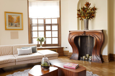 Mid-sized transitional formal and open concept medium tone wood floor living room photo in New York with beige walls, a standard fireplace, a wood fireplace surround and no tv
