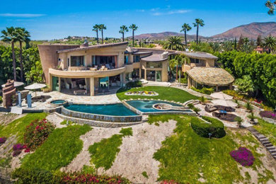 Large contemporary beige two-story stucco exterior home idea in San Diego with a tile roof
