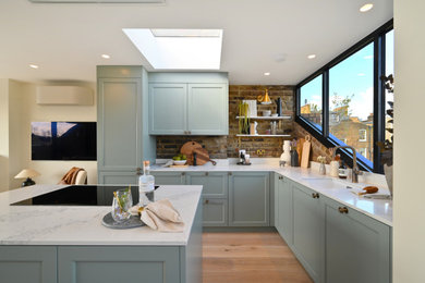 This is an example of a medium sized classic l-shaped open plan kitchen in London with an island.