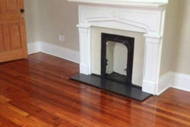 Example of a mid-sized trendy enclosed light wood floor and brown floor family room design in New Orleans with beige walls, a standard fireplace and a tile fireplace
