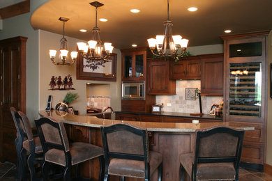 Example of a large classic l-shaped brown floor seated home bar design in Kansas City with raised-panel cabinets, an undermount sink, dark wood cabinets, granite countertops and beige backsplash
