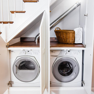 ボルチモアの小さいトラディショナルスタイルのおしゃれなランドリークローゼット (シェーカースタイル扉のキャビネット、白いキャビネット、木材カウンター、無垢フローリング、左右配置の洗濯機・乾燥機、茶色い床、茶色いキッチンカウンター) の写真