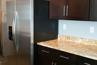 Inspiration for a mid-sized transitional single-wall dark wood floor kitchen remodel in Tampa with shaker cabinets, dark wood cabinets, granite countertops, stainless steel appliances and an island