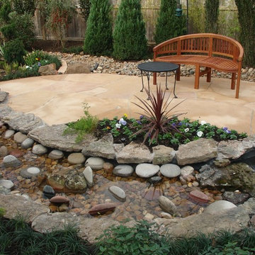 Landscaping with oversize pavers and backyard creek - hkns