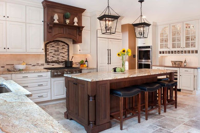 Inspiration for a large timeless u-shaped limestone floor enclosed kitchen remodel in Philadelphia with an undermount sink, raised-panel cabinets, white cabinets, granite countertops, beige backsplash, stone tile backsplash, stainless steel appliances and an island