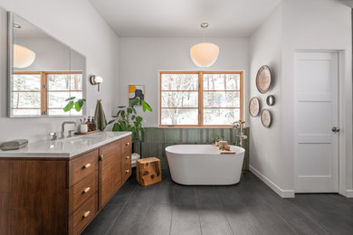 Example of a mid-sized minimalist master green tile and ceramic tile porcelain tile, black floor and double-sink bathroom design in Seattle with flat-panel cabinets, medium tone wood cabinets, a one-piece toilet, white walls, an undermount sink, quartz countertops, white countertops and a built-in vanity