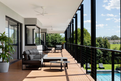 Inspiration for an expansive contemporary balcony in Melbourne with a roof extension and metal railing.