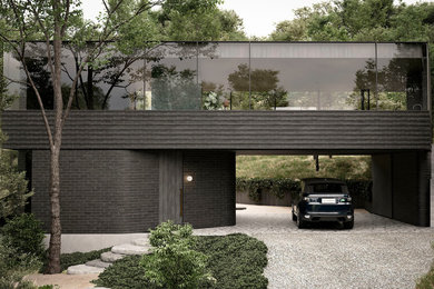 Photo of a mid-sized contemporary two-storey brick black house exterior in Melbourne with a flat roof.