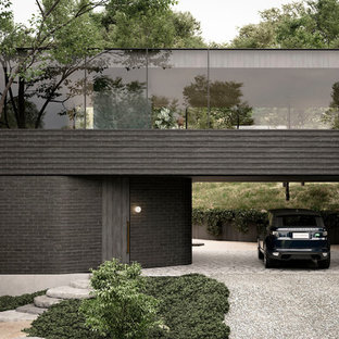 Inspiration för ett mellanstort funkis svart hus, med två våningar, tegel och platt tak