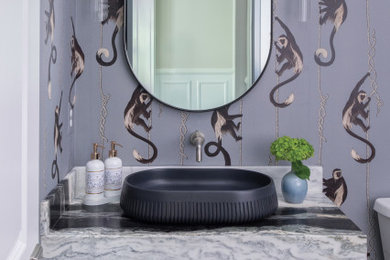 Example of a mid-sized eclectic dark wood floor, wallpaper and brown floor powder room design in DC Metro with a vessel sink, marble countertops, a floating vanity, purple walls and gray countertops