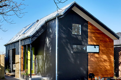 Photo of a contemporary one-storey black exterior in Melbourne with wood siding and a gable roof.