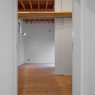 Inspiration pour un dressing minimaliste neutre avec un placard sans porte, un sol en bois clair et un plafond en poutres apparentes.