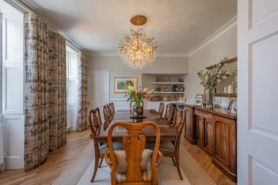 Large classic enclosed dining room in Dorset with beige walls and medium hardwood flooring.