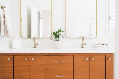 Mid-sized beach style white tile and ceramic tile porcelain tile, white floor and double-sink bathroom photo in San Francisco with flat-panel cabinets, medium tone wood cabinets, a one-piece toilet, white walls, an integrated sink, quartzite countertops, white countertops, a niche and a built-in vanity