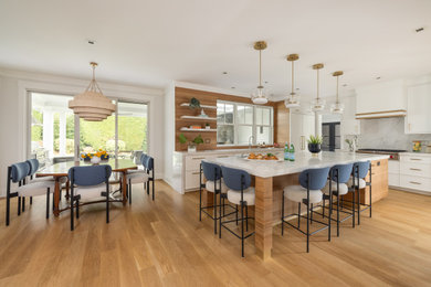 Large transitional kitchen photo in New York with white cabinets, quartz countertops, quartz backsplash, an island and white countertops