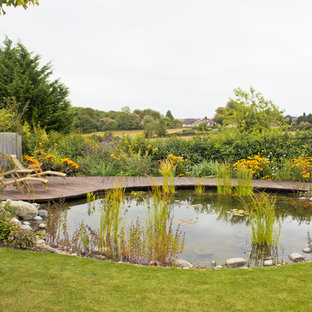Cette image montre un jardin avec une terrasse en bois ou composite arrière rustique de taille moyenne et l'été avec un point d'eau et une exposition ensoleillée.
