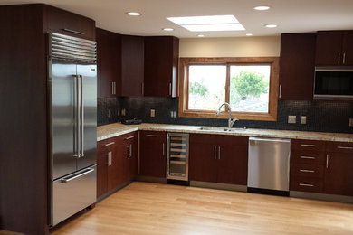 Enclosed kitchen - mid-sized modern l-shaped light wood floor enclosed kitchen idea in San Luis Obispo with a double-bowl sink, flat-panel cabinets, dark wood cabinets, granite countertops, black backsplash, mosaic tile backsplash, stainless steel appliances and no island