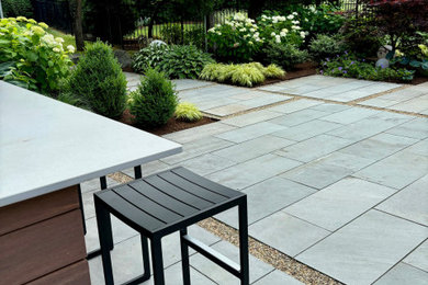 Example of a large backyard stone patio kitchen design in Boston with no cover