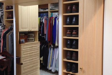 Large traditional men's dressing room in Boston with open cabinets, light wood cabinets and carpet.
