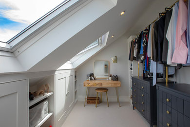 This is an example of a mid-sized transitional gender-neutral walk-in wardrobe in London with carpet, grey floor, shaker cabinets and white cabinets.