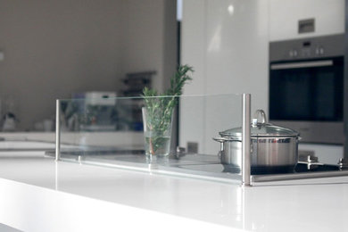 Photo of a contemporary kitchen in Frankfurt with glass sheet splashback.