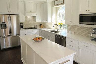 Inspiration for a french country l-shaped dark wood floor and brown floor kitchen pantry remodel in Dallas with a single-bowl sink, shaker cabinets, white cabinets, quartz countertops, beige backsplash, ceramic backsplash, stainless steel appliances, an island and white countertops