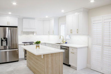 L-shaped porcelain tile and white floor kitchen photo in Toronto with a single-bowl sink, shaker cabinets, white cabinets, quartz countertops, white backsplash, quartz backsplash, stainless steel appliances, an island and white countertops