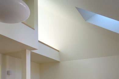 Modelo de salón abierto y blanco actual pequeño sin chimenea con paredes blancas, suelo de contrachapado, suelo marrón, papel pintado y papel pintado