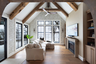 Example of a transitional exposed beam family room design in Minneapolis with a standard fireplace, a stone fireplace and a wall-mounted tv
