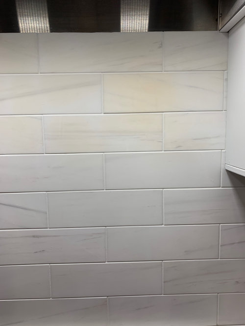sealed dolomites backsplash some tiles turning yellow, any suggestions