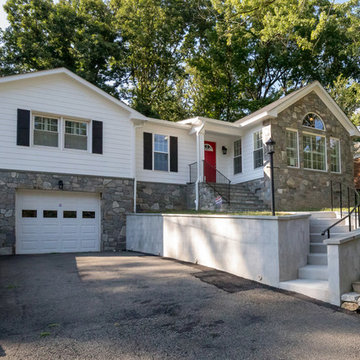 Exterior of house with updated stone veneer, siding and retaining walls.