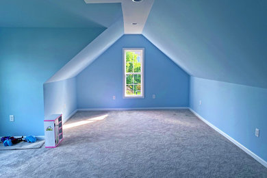 Diseño de cuarto de juegos minimalista con paredes azules y moqueta