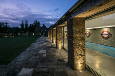Inspiration for a large contemporary courtyard rectangular lap pool in Gloucestershire with a pool house.